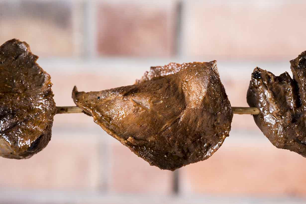 Several Organ Meats On a Wooden Skewer.