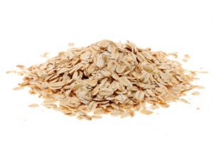A pile of rolled oats on a white background.