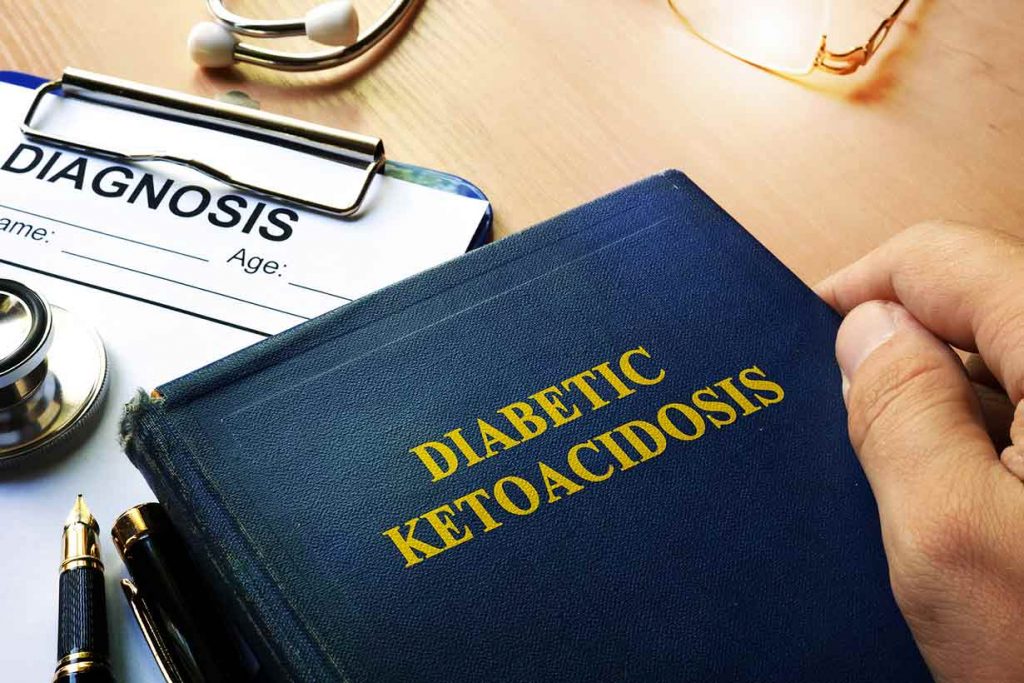 Someone holding a book which says "Diabetic Ketoacidosis" on the cover.