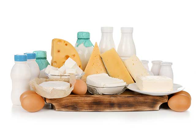 Fresh Dairy Foods and Whole Eggs On a Wooden Board.