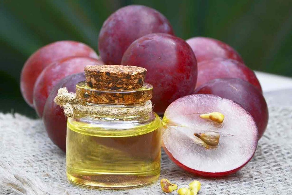 Grapeseed Oil Next To Grapes.