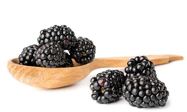 Several Ripe Blackberries On a Wooden Spoon.