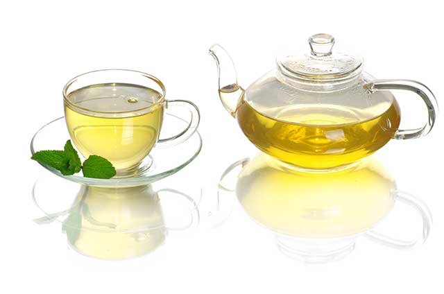 Green Tea In a Glass Cup With Glass Teapot.