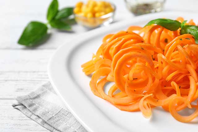 Spiralized Carrot Noodles On a White Plate.