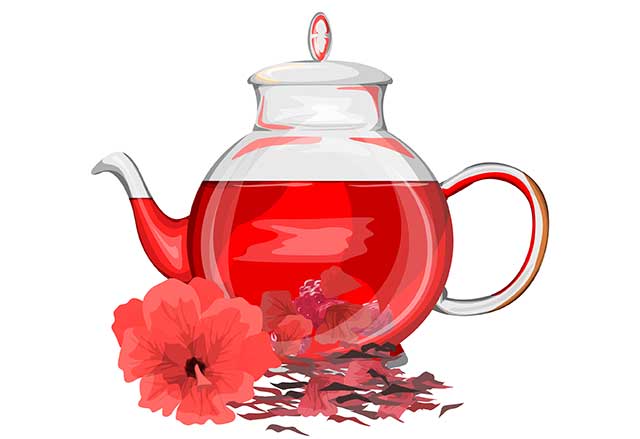 A Glass Jug of Hibiscus Tea Next To Dried Leaves.