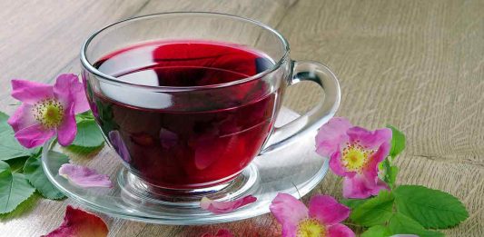 A Glass Cup of Hibiscus Tea On a Glass Saucer.