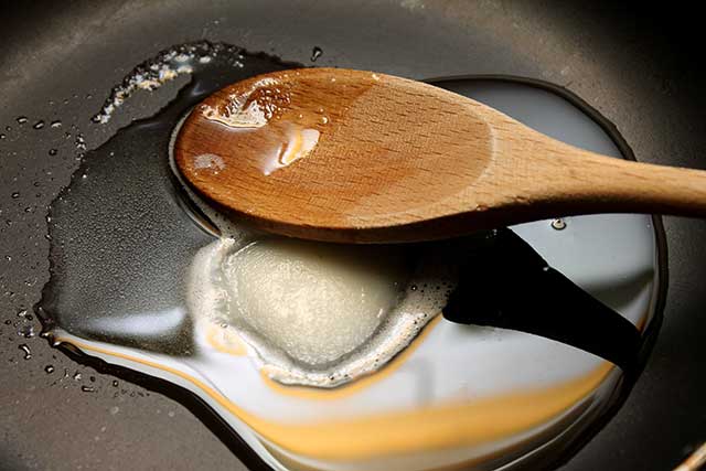 Melted Lard In a Frying Pan With Wooden Spoon.