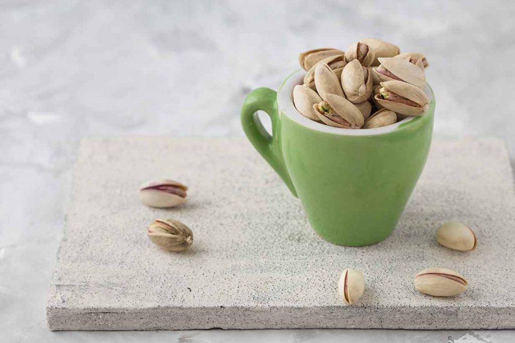 Pistachio Nuts In a Green Cup.