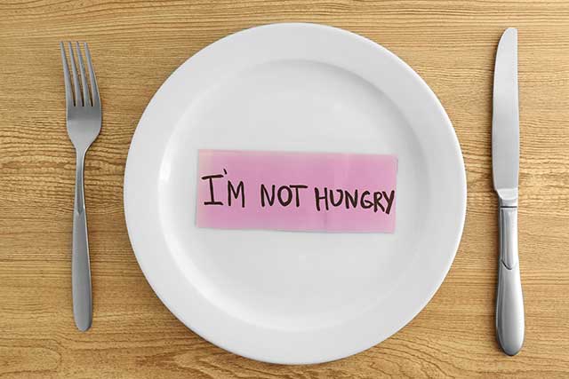 Empty Plate With the Words "I'm Not Hungry" Written On it.