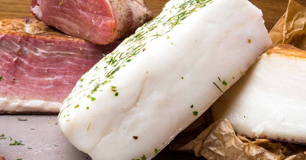 A white brick of pork lard next to meat.