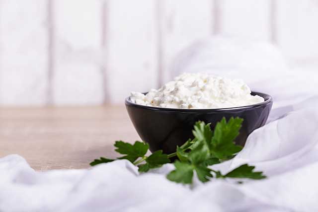 Fromage ricotta dans un bol noir.