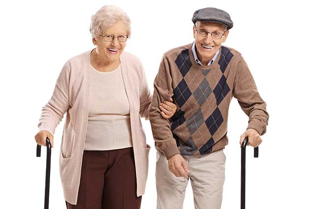 A Smiling Elderly Couple Walking Arm In Arm.