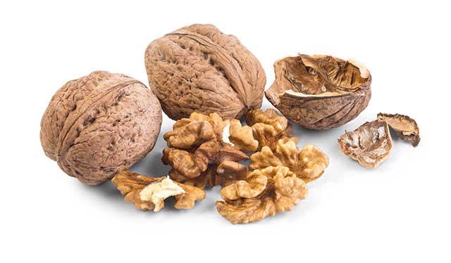 Whole and Shelled Walnuts Next To Each Other.