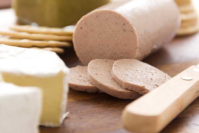 Liverwurst With Cheese and Crackers On a Wooden Board.