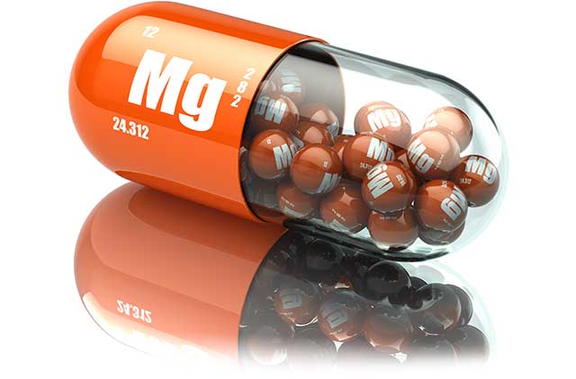 Magnesium Supplement Tablets Inside a Giant Capsule With 'Mg' On It.