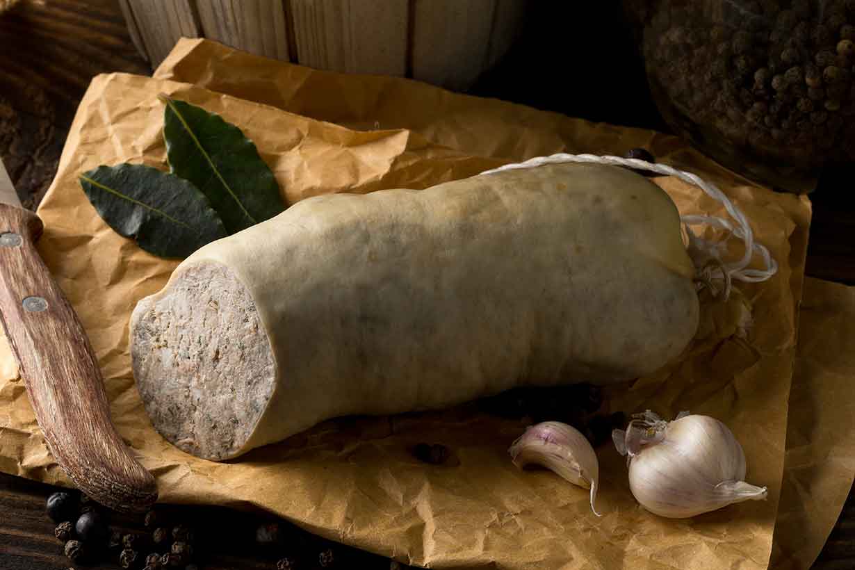 Liverwurst Sausage On Paper On a Wooden Table.