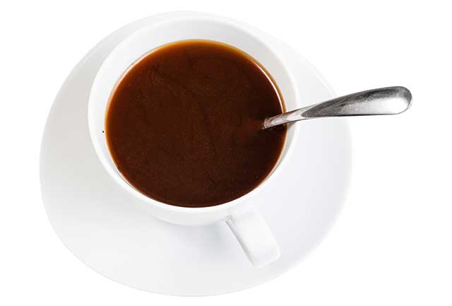 Black Coffee In White Mug On a White Saucer With Teaspoon.