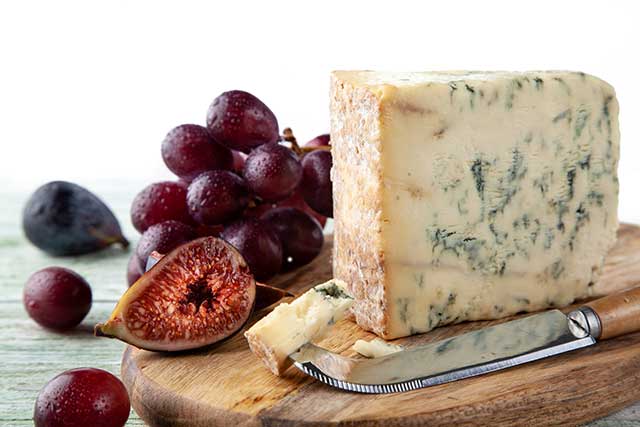 Blue Stilton Cheese On a Cheeseboard With Fruit Knife and Fruit.