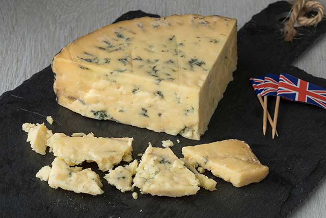 Blue Stilton On Cheese Board Next To Small British Flags.