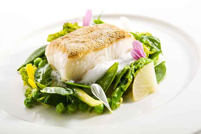 Thick White Halibut Fish Steak On a Plate With Vegetables.