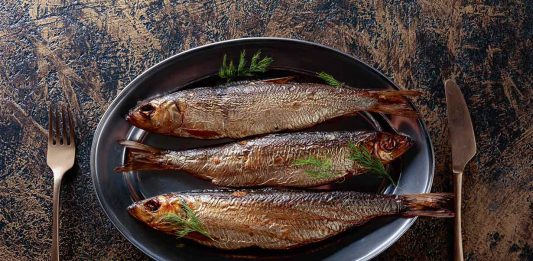 Three Grilled Whole Herring Fillets On a Plate.