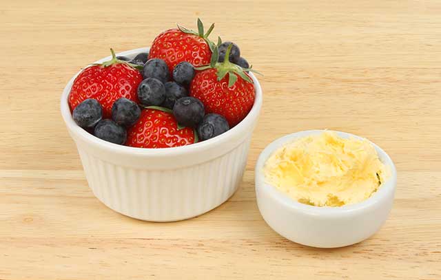 Clotted Cream and Mixed Berries In Separate Small Bowls.