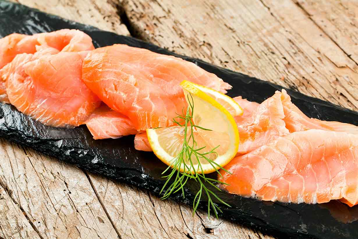 Smoked Salmon Slices On a Black Plate.