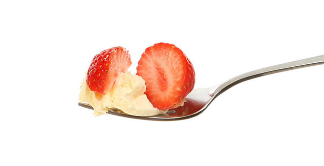 Strawberry Pieces and Clotted Cream On a Spoon.