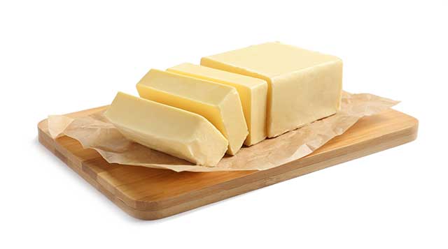 Block of Cut Butter On a Wooden Chopping Board.