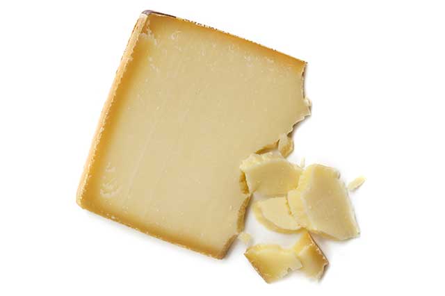 Close-up Image of Gruyere Cheese Block and Crumbly Pieces.