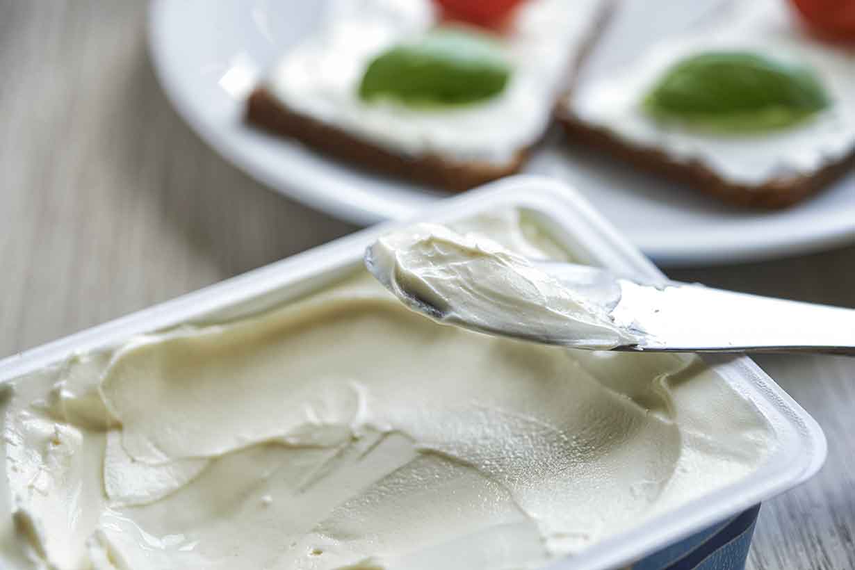 Knife and Tub of Cream Cheese Spread.