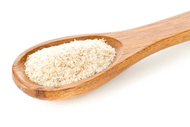 Psyllium Husk Powder On a Large Wooden Spoon.