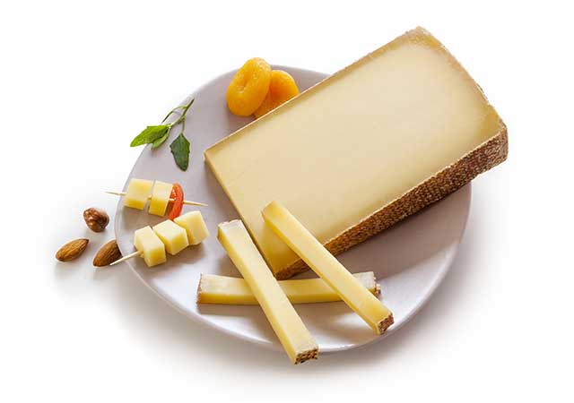 Swiss Gruyere Raw Cheese On a White Plate.