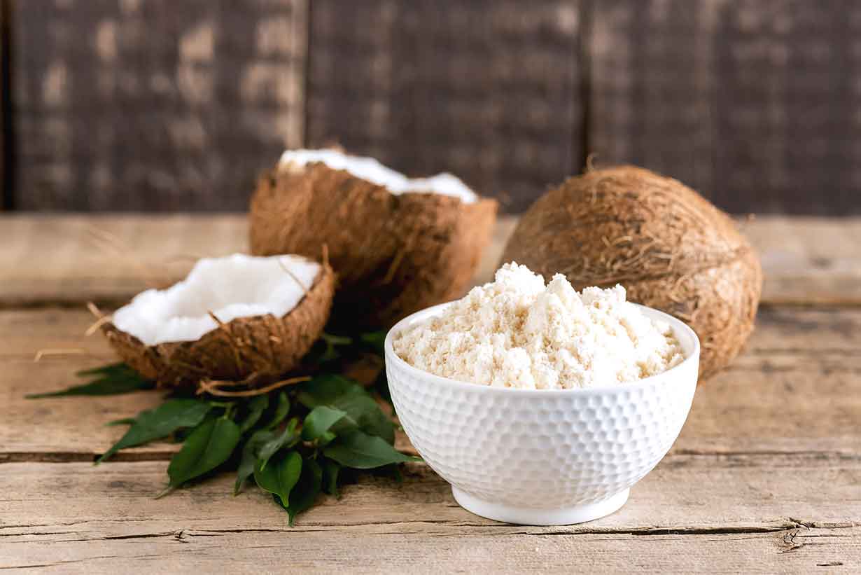 Bowl of Coconut Flour Next To Coconut