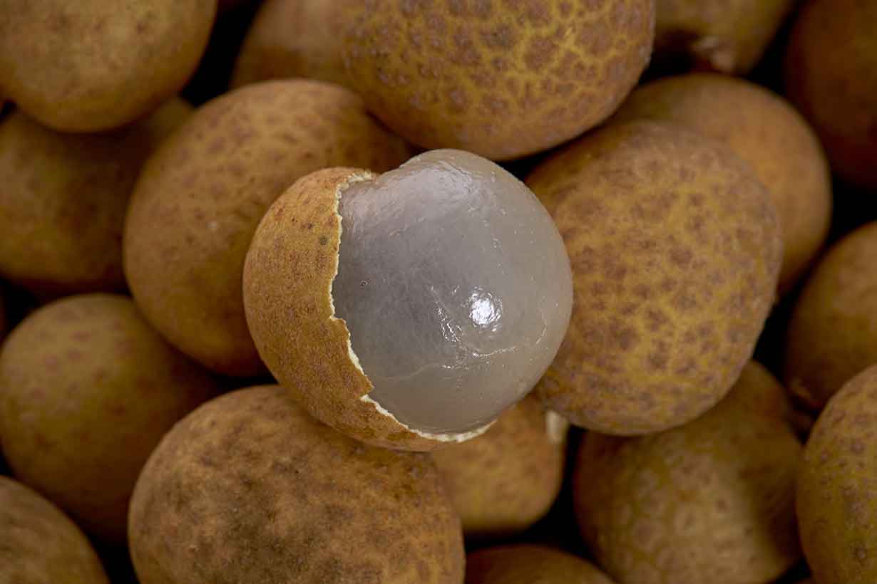 Numerous Longan Fruit In Their Peel, With One Unpeeled Fruit.