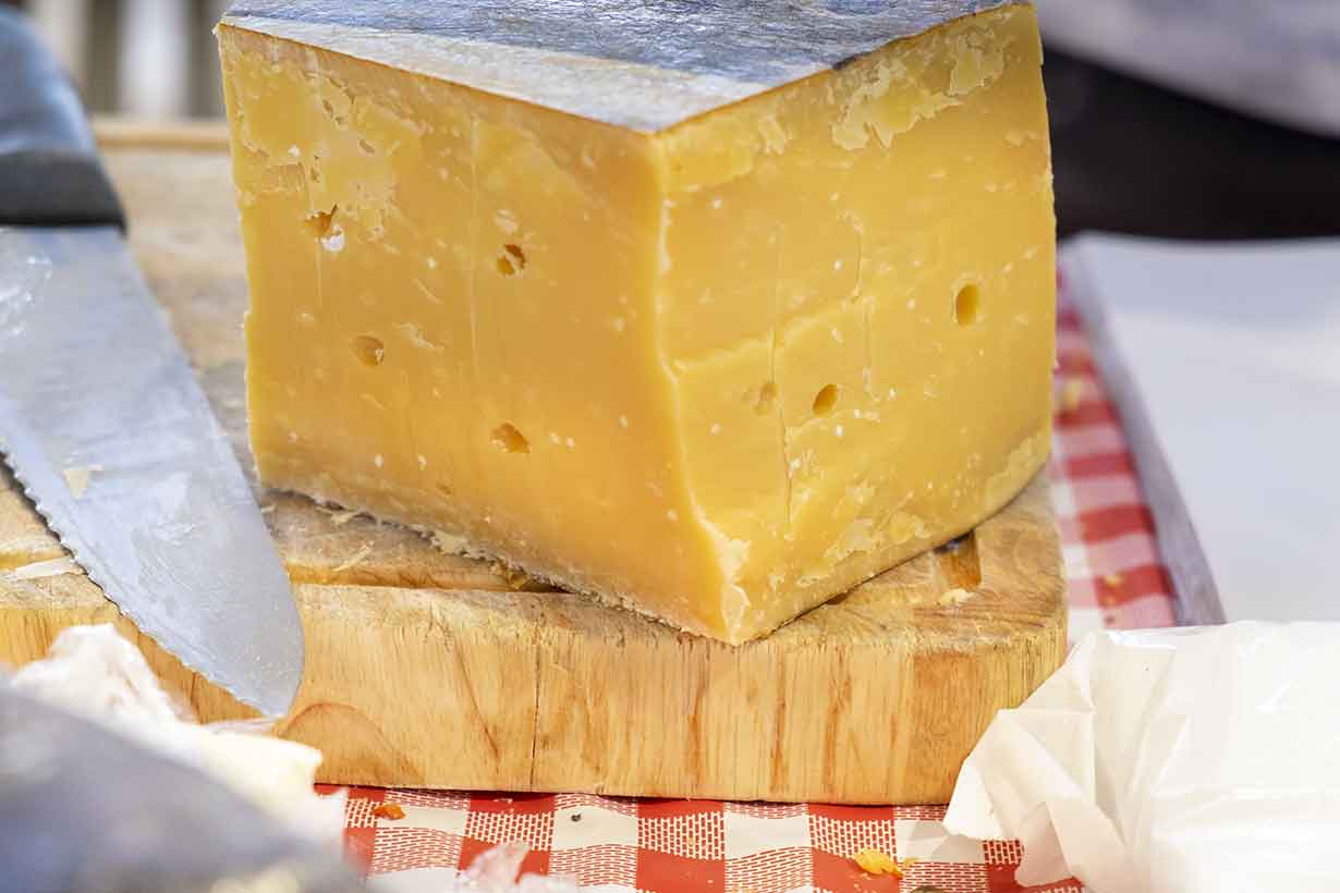 Aged Vintage Gouda Cheese On a Wooden Board.