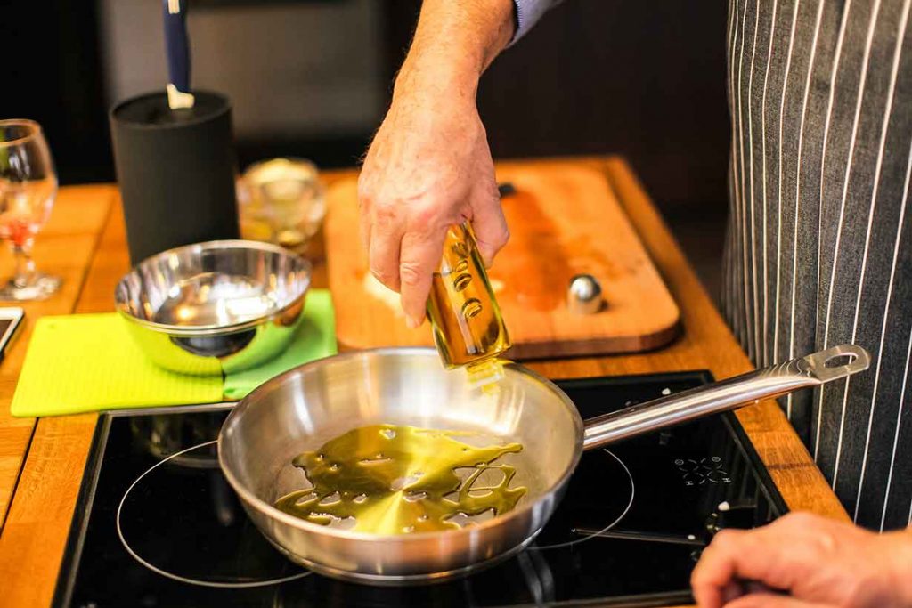 Chef Cooking With Extra Virgin Olive Oil.