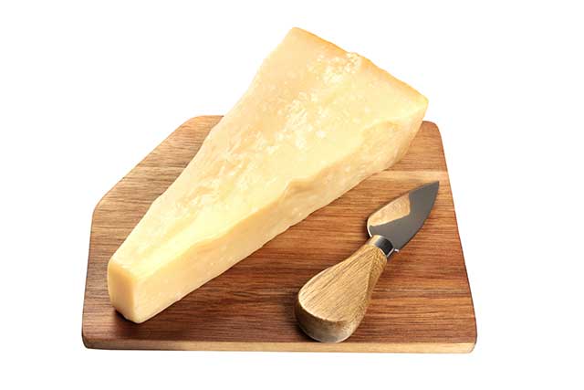 Aged Parmesan Cheese On a Wooden Chopping Board.