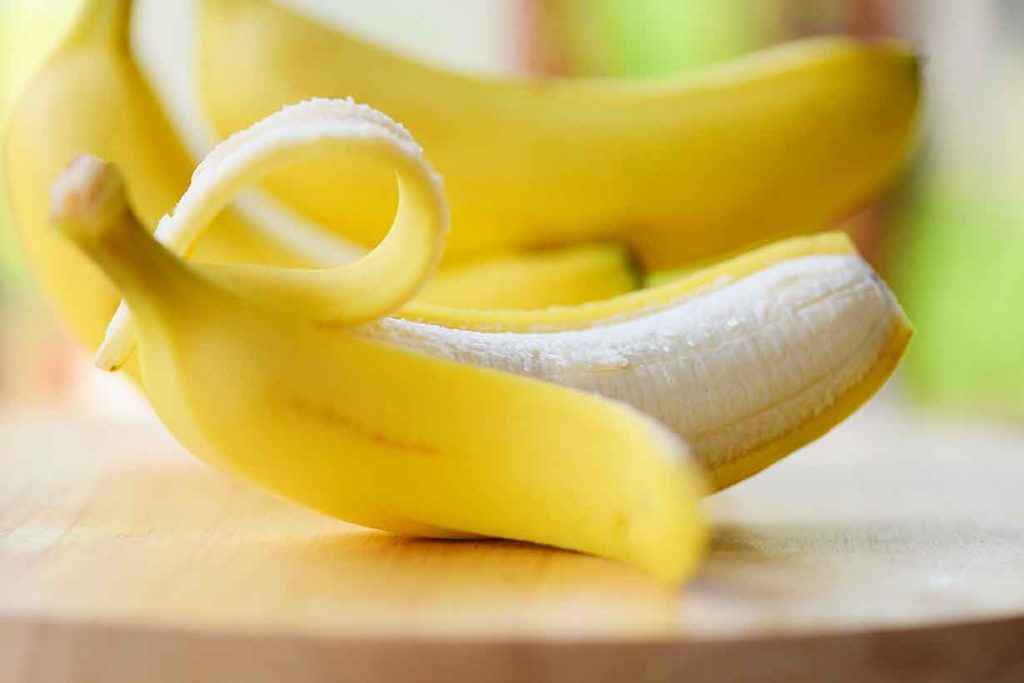 A Halfway Peeled Banana On a Wooden Table.