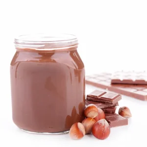 Jar of Nutella next to chocolate and hazelnuts.