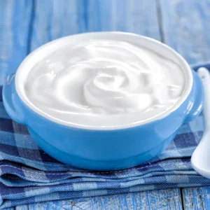 Sour cream in a blue bowl on a table.