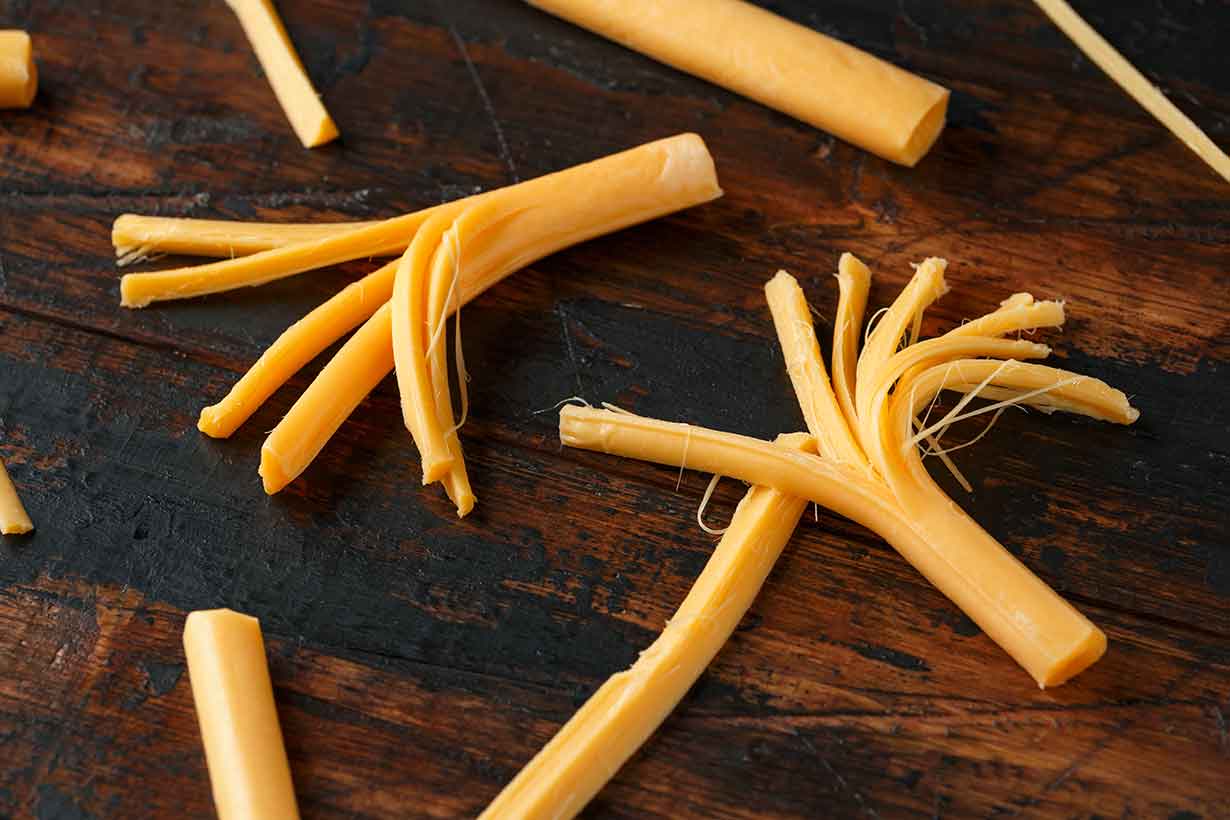 Sticks of String Cheese On a Wooden Surface.