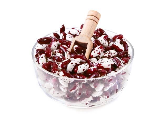 Raw anasazi beans in a clear glass bowl.