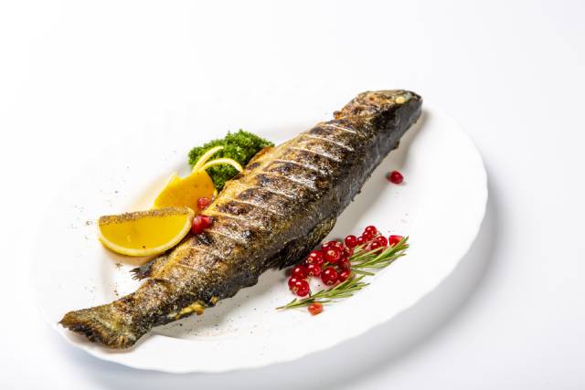 Grilled Trout On a Plate With Lemon Slice and Herbs.