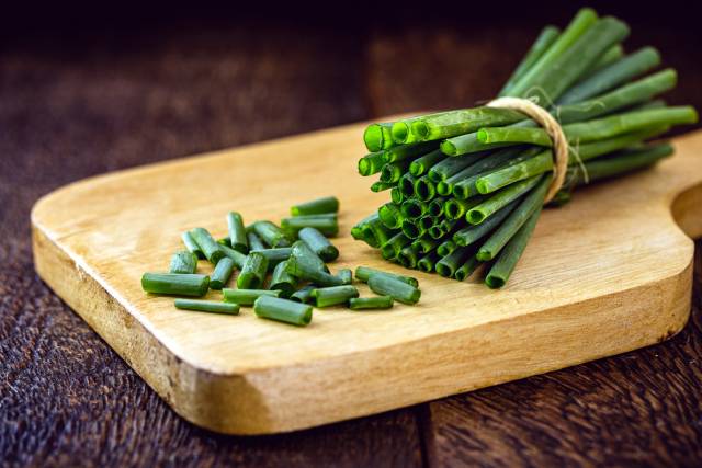 Sliced Chives On a Wooden Board.