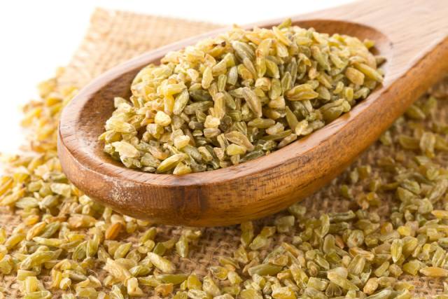 Freekeh (Roasted Wheat Grains) On a Wooden Spoon.