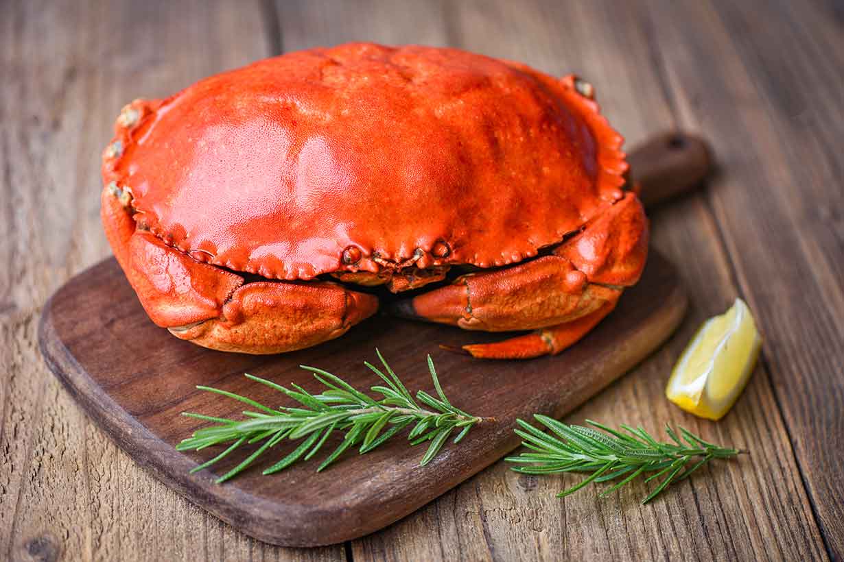 A Whole Cooked Crab On a Wooden Board.