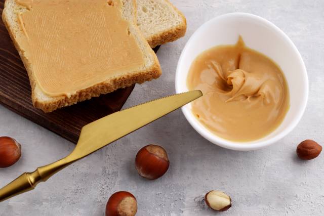 Hazelnut Butter In a White Bowl and Spread On Bread.