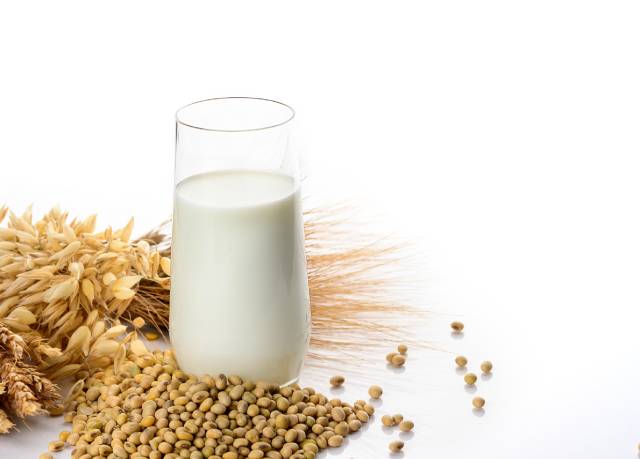 A Glass of Soy Milk Next To Soybeans.