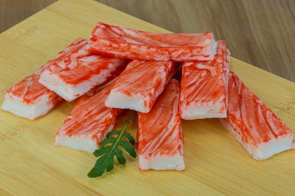 Imitation Crab Meat Sticks On a Wooden Surface.